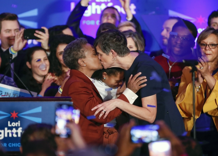 lori-lightfoot-qui-embrasse-sa-femme-amy-eshleman-avec-vivian-leur-fille-adoptee-au-milieu-le-soir-de-son-election-le-2-avril-2019.jpg