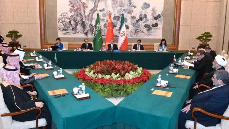 Wang Yi, le plus haut diplomate chinois, au centre, préside une réunion à huis clos entre l’Iran, dirigée par Ali Shamkhani, secrétaire du Conseil suprême de sécurité nationale iranien, à droite, et l’Arabie saoudite, dirigée par le conseiller saoudien à la sécurité nationale Musaad bin Mohammed al-Aiban, à gauche, à Pékin le 11 mars. (Xinhua via AP)