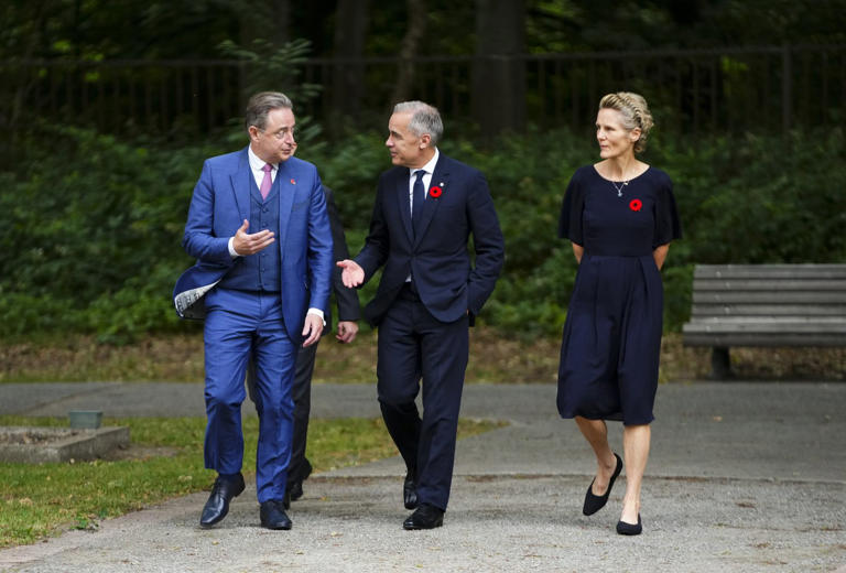 Le premier ministre Mark Carney, au centre, et son épouse Diana Fox Carney sont accueillis par le premier ministre belge Bart De Wever à leur arrivée au cimetière militaire Schoonselhof, à Anvers, en Belgique, le lundi 23 juin 2025. LA PRESSE CANADIENNE/Sean Kilpatrick © La Presse Canadienne