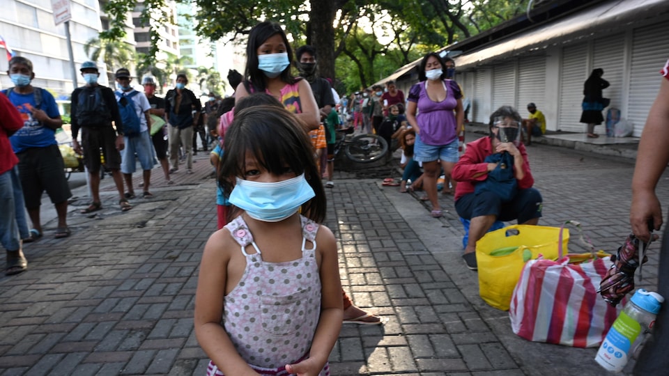 Des sans-abris font la file pour recevoir un repas le 8 décembre 2020, à Manille, aux Philippines, où les associations caritatives peinent à fournir à la demande depuis le début de la pandémie.<br />PHOTO : GETTY IMAGES / TED ALJIBE