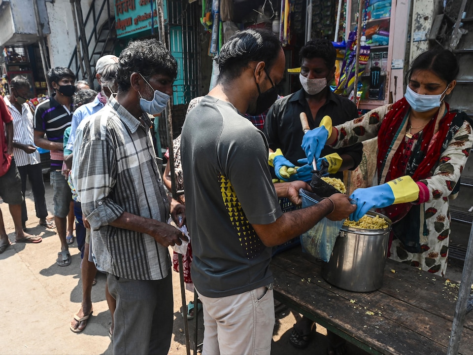 Des volontaires d'une organisation non gouvernementale distribuent de la nourriture à des Indiens dans le besoin à Mumbai, le 15 avril 2021.<br />PHOTO : AFP VIA GETTY IMAGES / INDRANIL MUKHERJEE