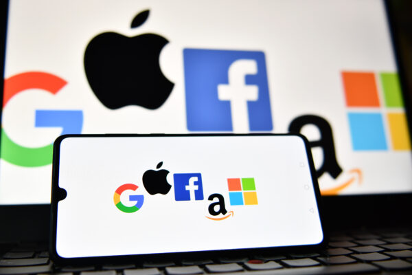 Logos de Google, Apple, Facebook, Amazon et Microsoft affichés sur un téléphone mobile et un écran d’ordinateur portable. (Justin Tallis/AFP via Getty Images)